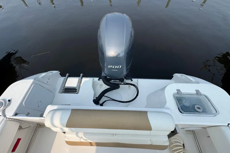 Slide: The Image of 2023 Edgewater 208CC boat with Yamaha 200 engine, featuring a swim ladder and seating. - 11