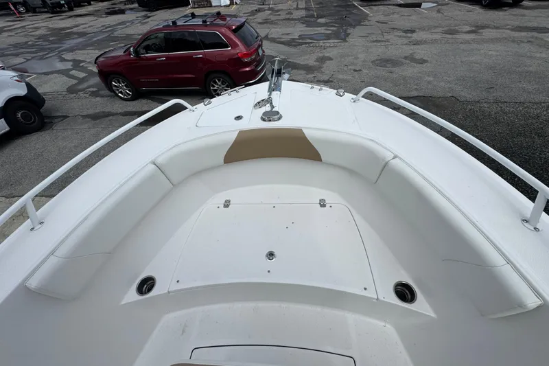 Slide: The Image of 2023 Edgewater 208CC boat bow with seating, parked in a lot. - 13