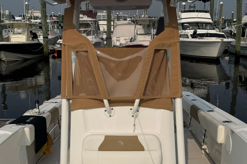 Slide: The Image of 2023 Edgewater 208CC boat docked at marina with other vessels. - 15