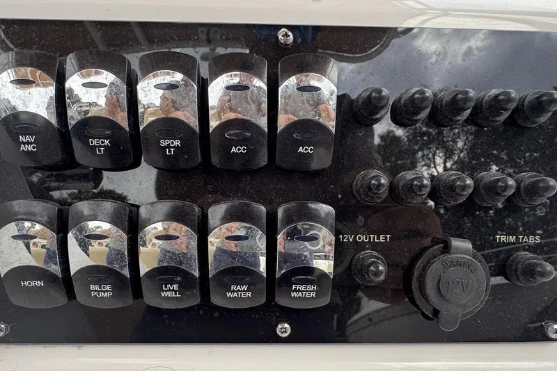 Slide: The Image of Control panel of 2023 Edgewater 208CC boat with various switches and 12V outlet. - 20