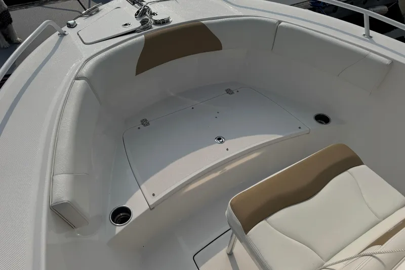 Slide: The Image of 2023 Edgewater 208CC boat interior with cushioned seating and storage compartment. - 26