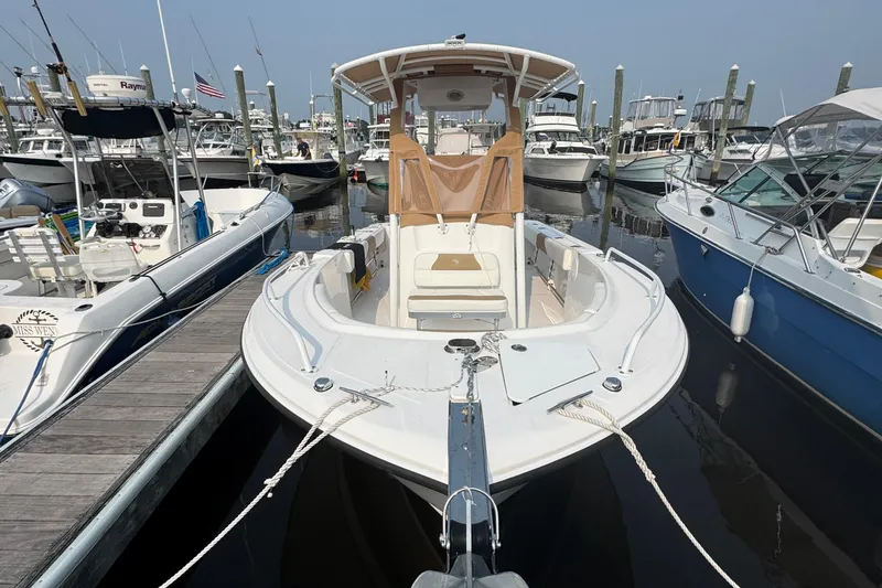 Slide: The Image of 2023 Edgewater 208CC boat docked at a marina, surrounded by other vessels. - 3