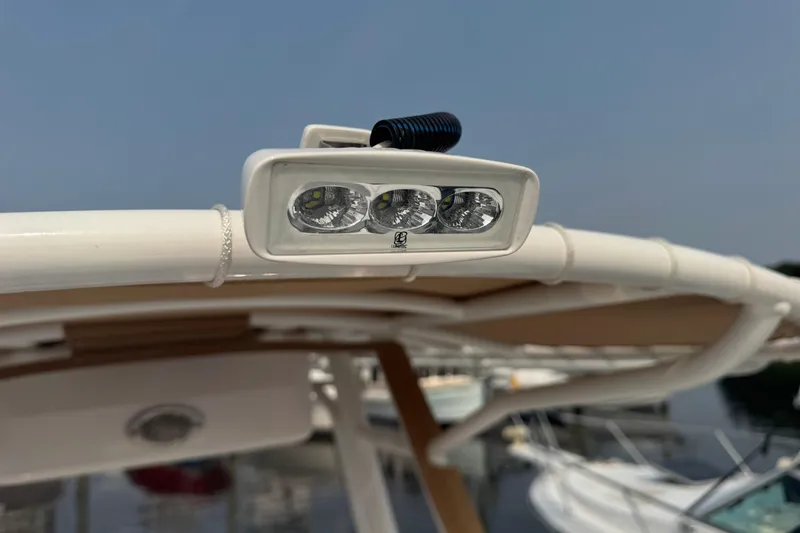 Slide: The Image of LED light on 2023 Edgewater 208CC boat's canopy, docked by the water. - 30