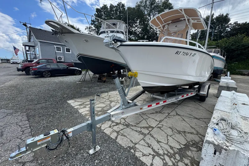 Slide: The Image of 2023 Edgewater 208CC boat on trailer at marina, clear sky background. - 4