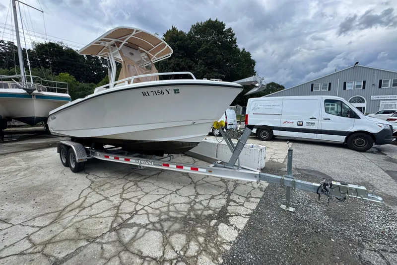 Slide: The Image of 2023 Edgewater 208CC boat on trailer in a marina parking lot. - 6