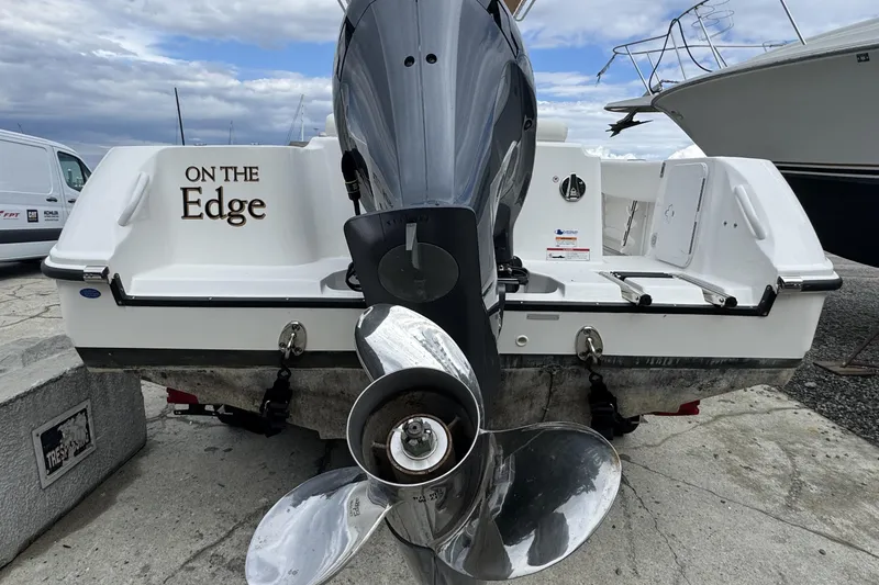 Slide: The Image of 2023 Edgewater 208CC boat with "On The Edge" text, docked with visible outboard motor. - 9