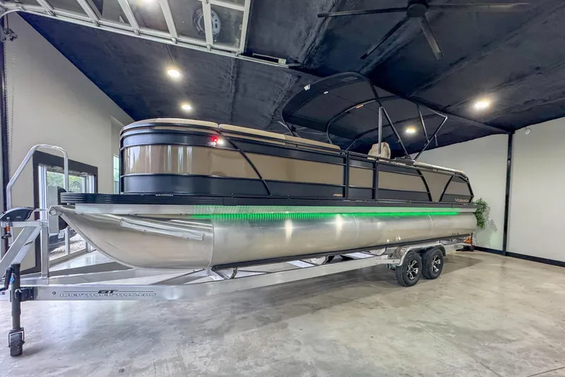 The Image of 2026 Veranda Relax VR265RC pontoon boat on trailer in showroom. - 0