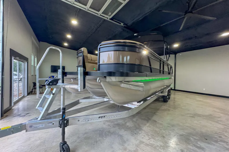 Slide: The Image of 2026 Veranda Relax VR265RC pontoon boat in showroom with green LED lights. - 2