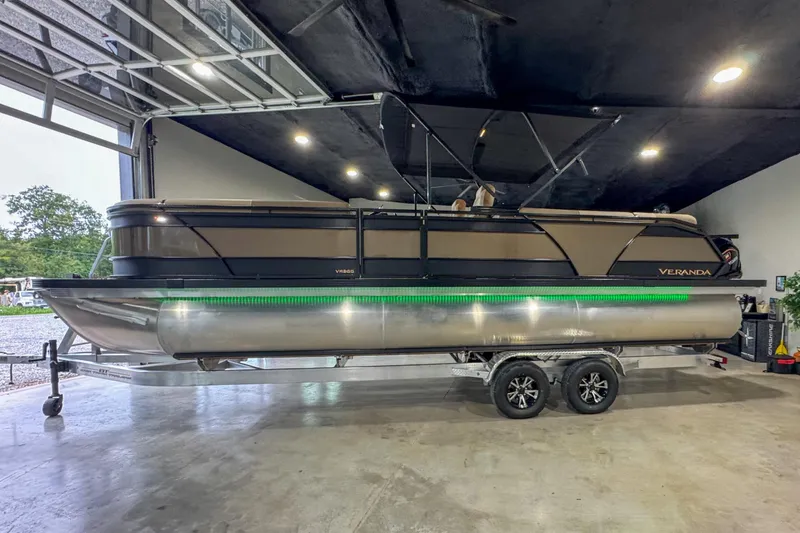 Slide: The Image of 2026 Veranda Relax VR265RC pontoon boat in showroom, featuring powerful outboard motor. - 4