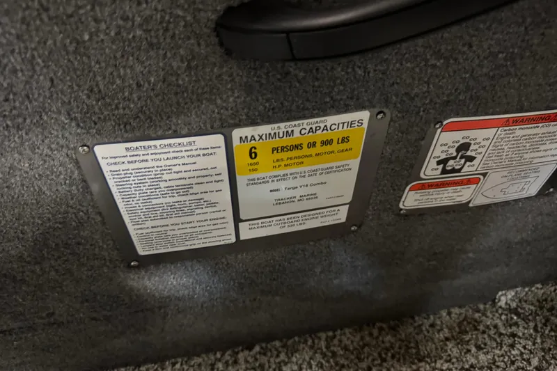 Slide: The Image of 2015 Tracker Targa V-18 Combo capacity and safety labels on boat interior. - 11