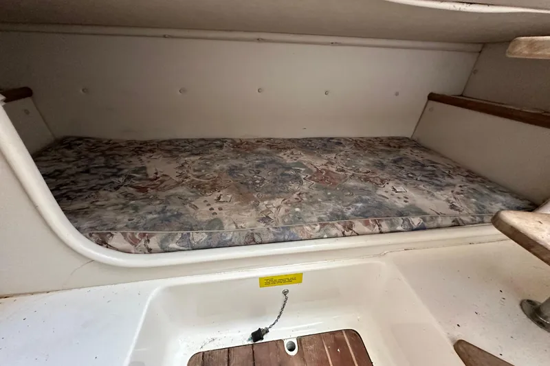 Slide: The Image of 2000 Pursuit 2870 Walkaround cabin interior with patterned mattress and wooden accents. - 11