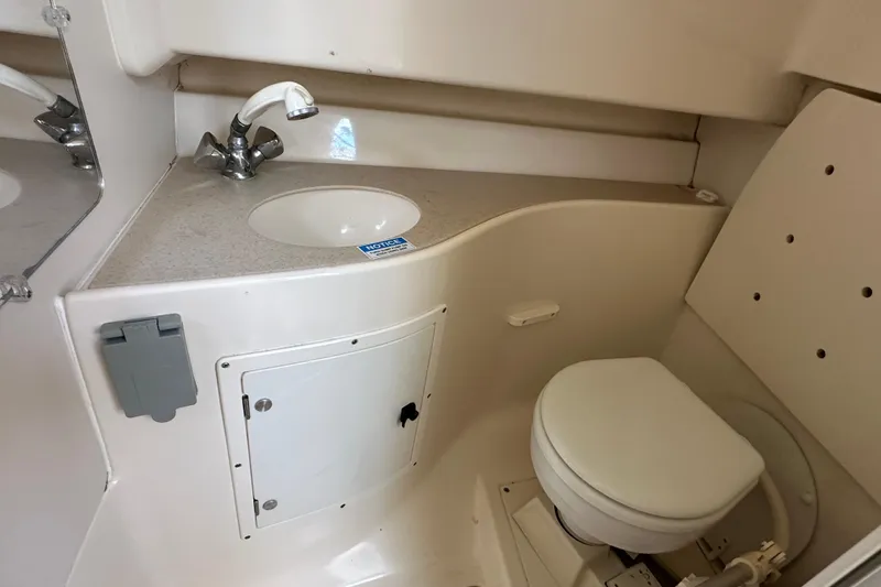 Slide: The Image of 2000 Pursuit 2870 Walkaround boat bathroom with sink and toilet. - 12