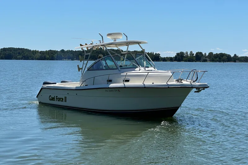 Slide: The Image of 2000 Pursuit 2870 Walkaround boat on calm lake with clear blue sky. - 4