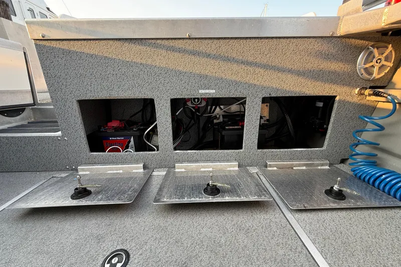Slide: The Image of 2023 Thunder Jet 22 Alexis Pro boat storage compartment with textured flooring and metal accents. - 12