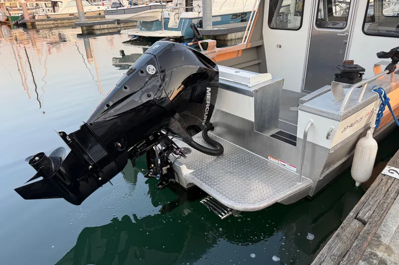 Slide: The Image of 2023 Thunder Jet 22 Alexis Pro boat interior with motor, docked on calm water. - 4