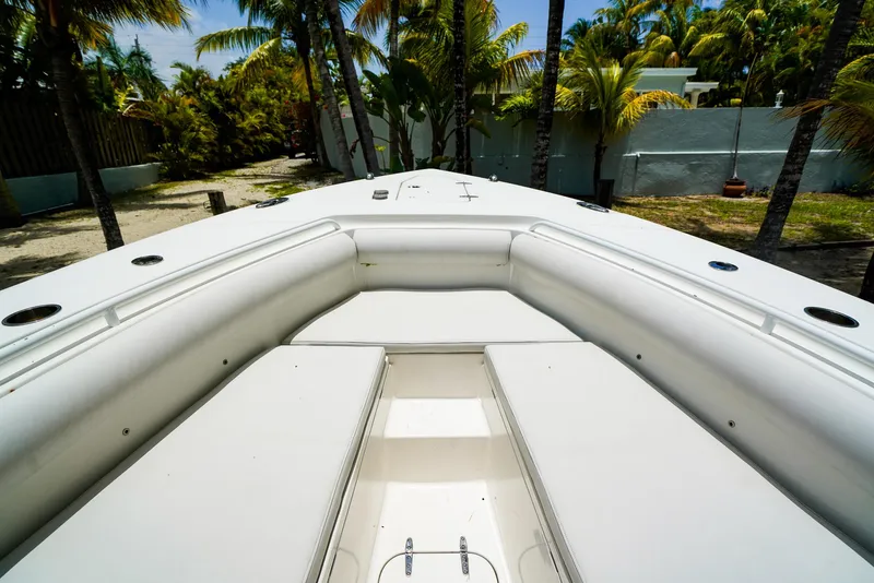 Slide: The Image of 2016 Sea Hunt Gamefish 30 boat interior with white seating, surrounded by palm trees. - 16
