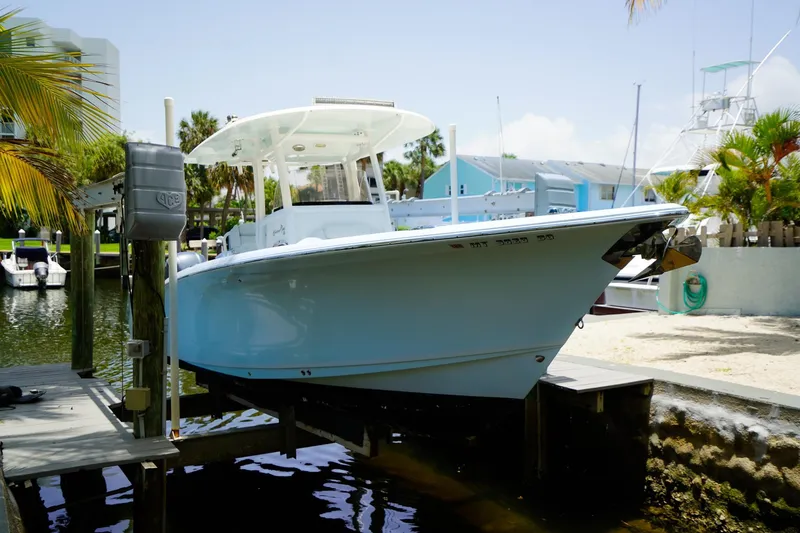 Slide: The Image of 2016 Sea Hunt Gamefish 30 boat docked near palm trees and waterfront homes. - 2