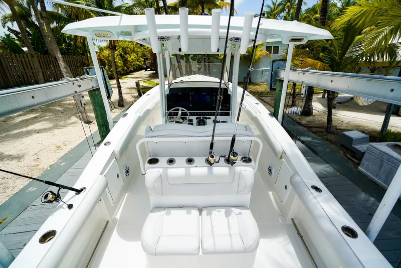Slide: The Image of 2016 Sea Hunt Gamefish 30 boat with fishing rods, docked near palm trees. - 5