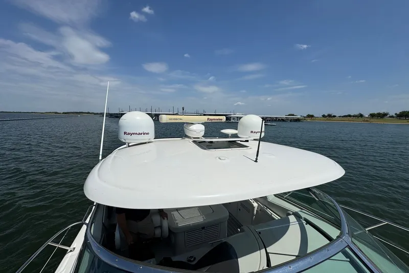 Slide: The Image of 2010 Sea Ray 390 Sundancer on water, featuring Raymarine equipment under a clear sky. - 10