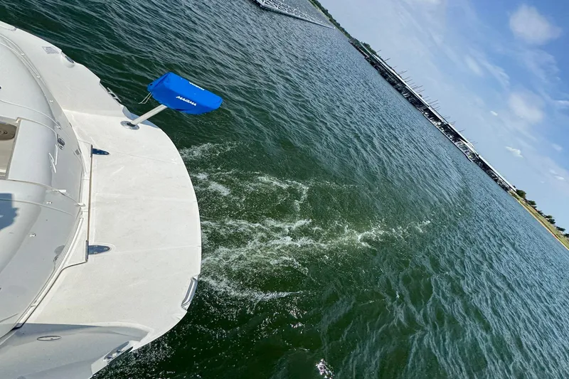 Slide: The Image of 2010 Sea Ray 390 Sundancer cruising on a sunny day, with marina in the background. - 11