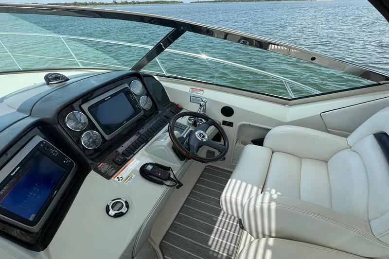 Slide: The Image of Helm of 2010 Sea Ray 390 Sundancer yacht with modern controls and comfortable seating. - 13