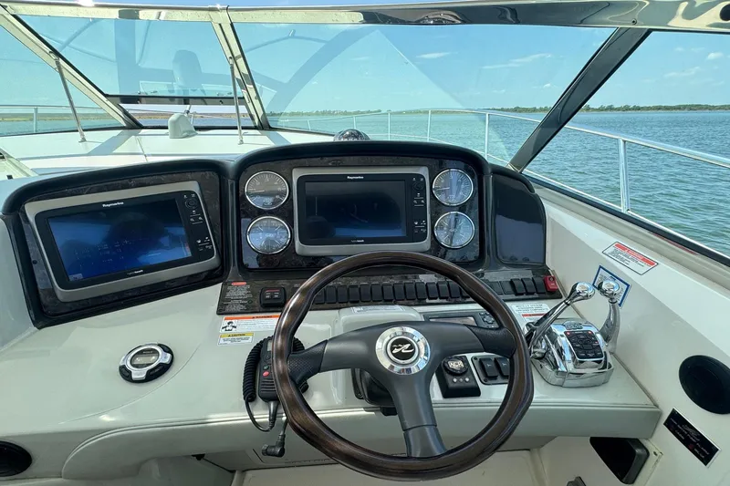 Slide: The Image of Cockpit of 2010 Sea Ray 390 Sundancer with navigation screens and steering wheel. - 14