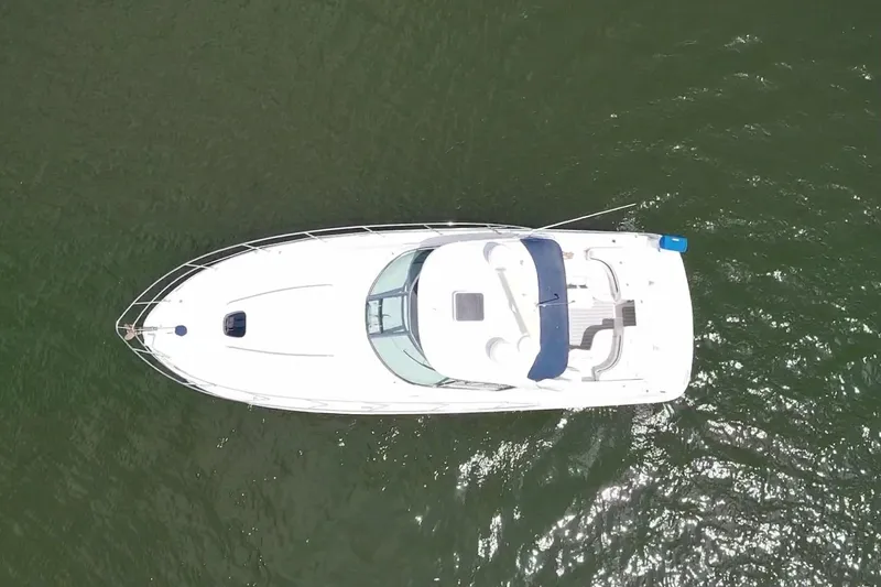Slide: The Image of Top view of a 2010 Sea Ray 390 Sundancer yacht on green water. - 2