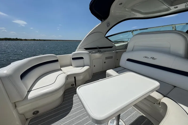 Slide: The Image of Luxurious 2010 Sea Ray 390 Sundancer yacht interior with white seating and table, overlooking serene water. - 22