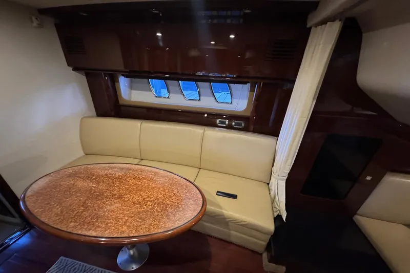 Slide: The Image of Luxurious interior of 2010 Sea Ray 390 Sundancer with leather seating and wooden table. - 28