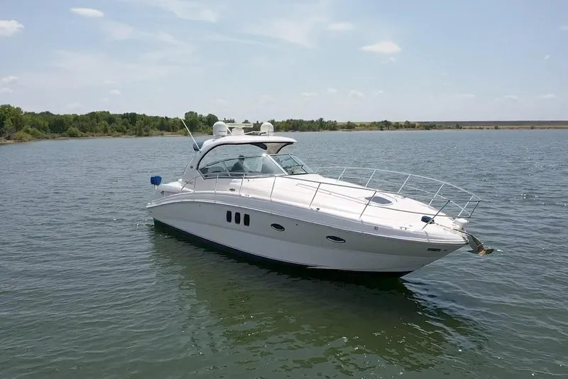Slide: The Image of 2010 Sea Ray 390 Sundancer yacht cruising on a serene lake under a clear sky. - 3