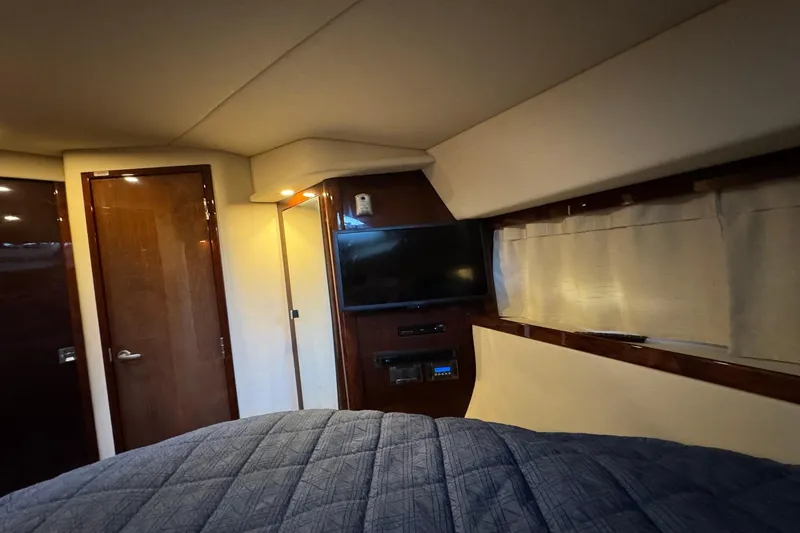 Slide: The Image of Interior cabin of 2010 Sea Ray 390 Sundancer with TV and wood paneling. - 35