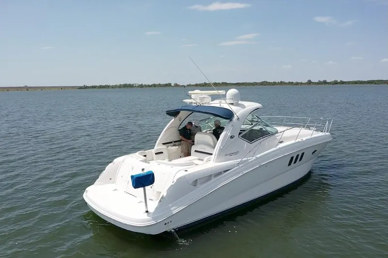 Slide: The Image of 2010 Sea Ray 390 Sundancer yacht cruising on a calm lake under a clear sky. - 4