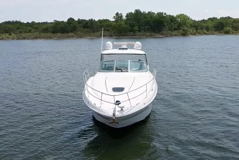 Slide: The Image of 2010 Sea Ray 390 Sundancer yacht on calm water, surrounded by lush greenery. - 6