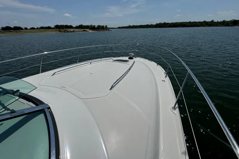 Slide: The Image of 2010 Sea Ray 390 Sundancer yacht cruising on a serene lake under a clear sky. - 9
