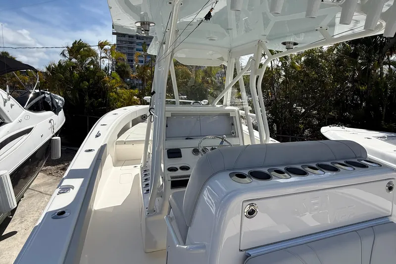 Slide: The Image of 2022 SeaVee 322z boat with sleek design, docked among other vessels, under clear blue sky. - 2