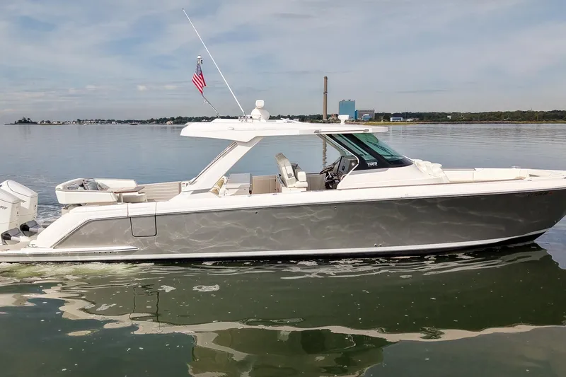 Slide: The Image of 2025 Tiara Yachts 43 LS luxury boat on calm water, side view. - 10