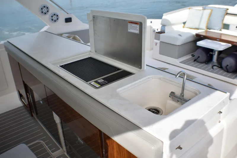 Slide: The Image of Luxury outdoor kitchen on 2025 Tiara Yachts 43 LS, featuring sink and grill. - 37