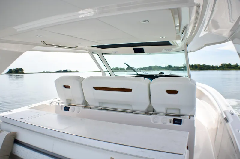 Slide: The Image of 2025 Tiara Yachts 43 LS interior, featuring sleek seating and modern design on calm waters. - 44