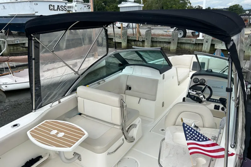 Slide: The Image of 2017 Boston Whaler 230 Vantage boat interior with seating, table, and American flag. - 3