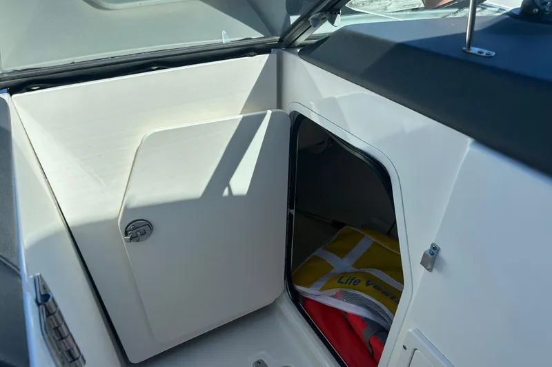 Slide: The Image of 2017 Boston Whaler 230 Vantage storage compartment with life vest inside. - 9