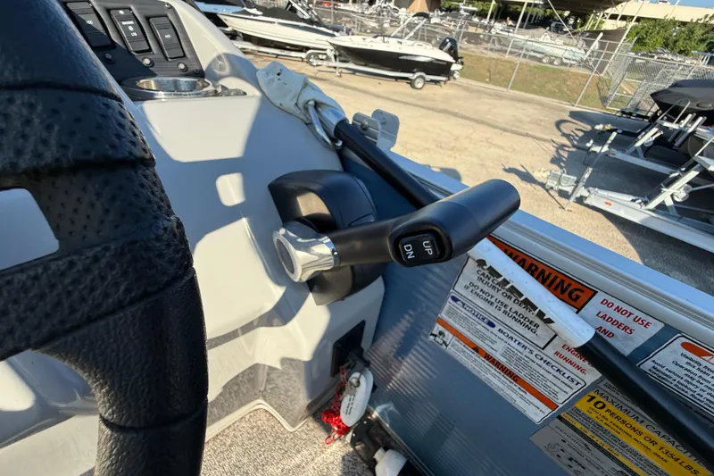 Slide: The Image of 2021 Bennington 20SFi boat controls and steering wheel, with warning labels visible. - 24