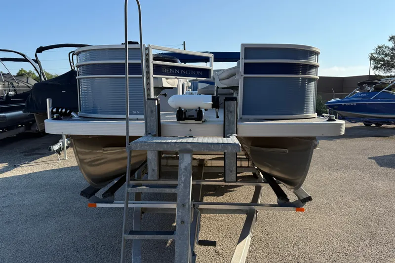 Slide: The Image of 2021 Bennington 20SFi pontoon boat on trailer, parked outdoors under clear sky. - 3