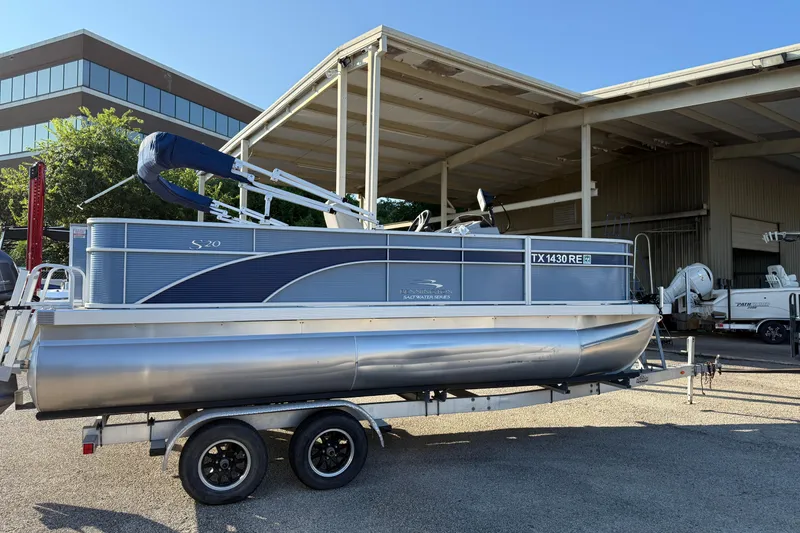 Slide: The Image of 2021 Bennington 20SFi pontoon boat on trailer, parked near a building. - 5