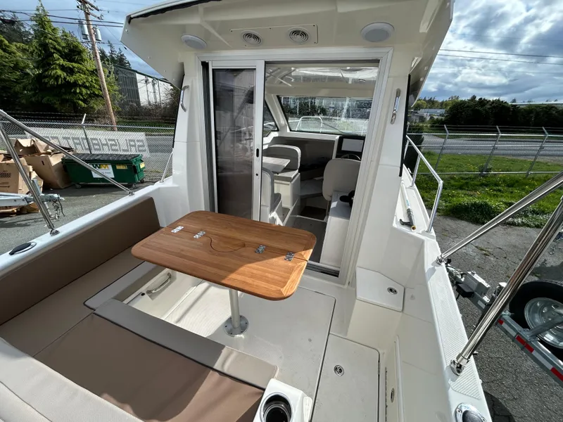 Slide: The Image of 2023 Bayliner Trophy T23 Explorer boat interior with seating and table. - 11