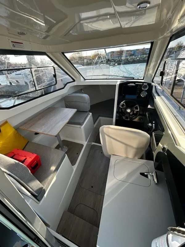 Slide: The Image of 2023 Bayliner Trophy T23 Explorer interior with seating, table, and helm. - 8