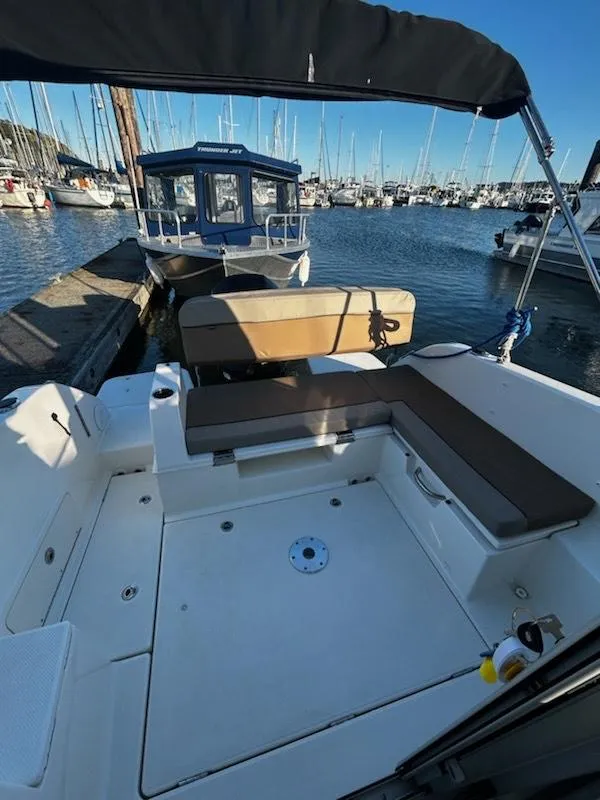 Slide: The Image of 2023 Bayliner Trophy T23 Explorer boat interior at marina, featuring spacious seating and modern design. - 9