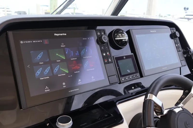 Slide: The Image of 2023 Aquila 36 Sport dashboard with dual Raymarine displays and navigation controls. - 13