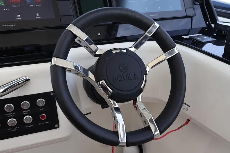 Slide: The Image of Steering wheel of 2023 Aquila 36 Sport boat with control panel and touchscreen display. - 14