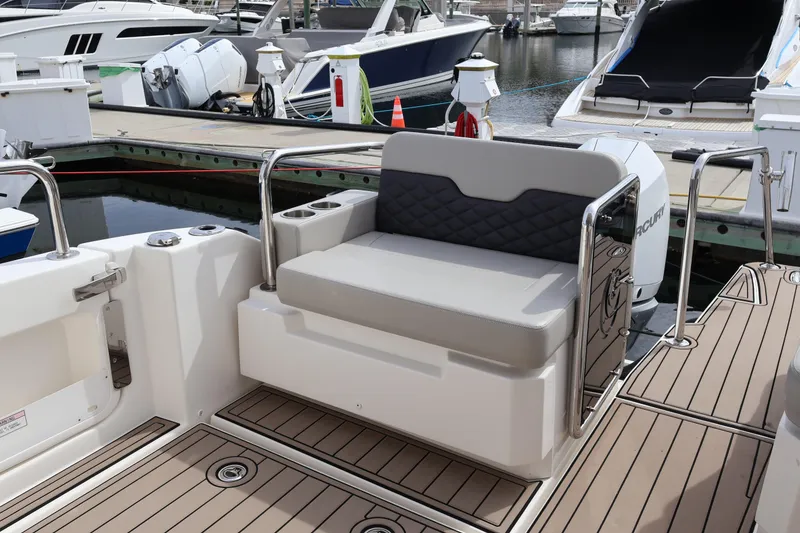 Slide: The Image of Aquila 36 Sport 2023 boat with cushioned seating at a marina dock. - 39