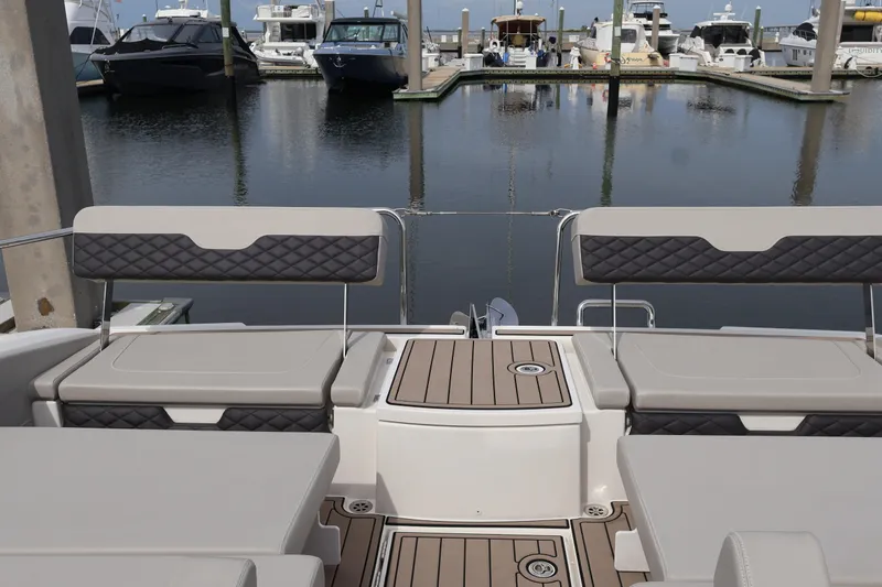 Slide: The Image of 2023 Aquila 36 Sport boat interior with cushioned seating at marina. - 45